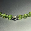 Close-up of the sterling silver John Alex signature bead with 2 mm and 4 mm peridot beads