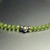 Close-up of the sterling silver John Alex signature bead with 3 mm faceted peridot beads
