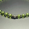 Close-up of the sterling silver John Alex signature bead with 4 mm peridot beads